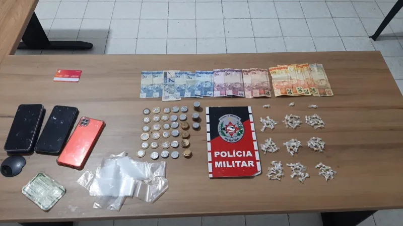 Maringá 98 FM — &nbsp; Após denúncias anônimas, a Polícia Militar de Pombal desarticulou um ponto de tráfico de drogas no município no bairro Pereiros. Ao notar a aproximação da viatura, uma mulher identificada como Franciene Ferreira de Oliveira, a “Cilene”, tentou descartar um pacote com 20 pedras de substância análoga ao crack. Durante a revista na residência, os policiais encontraram mais entorpecentes, totalizando 93 pedrinhas de substância análoga ao crack apreendidas na ocorrência. A suspeita confessou o crime e afirmou que a droga pertencia ao seu companheiro, Juberlanio de Sousa Silva, que não foi localizado. Franciene foi presa em flagrante e levada à [&hellip;]