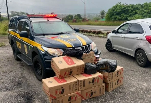 Maringá 98 FM — A Polícia Rodoviária Federal (PRF) apreendeu na Paraíba uma carga de aproximadamente 5 mil maços de cigarros contrabandeados do Paraguai. A ação ocorreu no km 96 da BR-104, no município de Esperança, na madrugada do último sábado (25). De acordo com a PRF, a abordagem aconteceu após os policiais visualizaram que um carro transportava uma grande quantidade de material no banco traseiro, parcialmente coberto por uma manta preta. “Ao ser parado, o condutor, um homem de 56 anos, confessou prontamente que transportava cigarros contrabandeados e que o destino final da mercadoria seria a cidade de Passa e Fica, no Rio [&hellip;]
