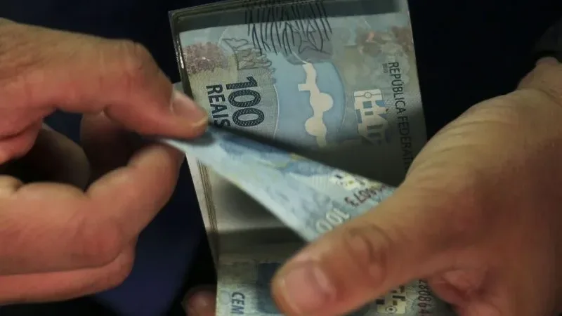Maringá 98 FM — O governo federal propôs um salário mínimo de R$ 1.717 para o ano que vem, com aumento nominal de 5,92%. O valor consta do Projeto da Lei de Diretrizes Orçamentárias (PLDO) de 2027, enviado nesta quarta-feira (15) ao Congresso Nacional. O reajuste segue a projeção de 3,06% para o Índice Nacional de Preços ao Consumidor (INPC) para os 12 meses terminados em novembro mais o crescimento da economia em 2025, limitado ao crescimento de gastos de 2,5% acima da inflação, determinado pelo arcabouço fiscal. A estimativa para o INPC também consta do PLDO. O projeto também apresentou previsões de R$ [&hellip;]