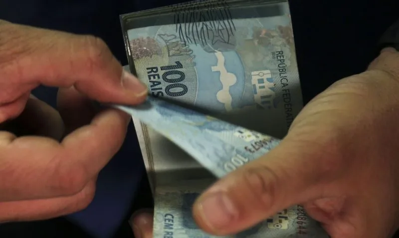 Maringá 98 FM — O governo federal propôs um salário mínimo de R$ 1.717 para o ano que vem, com aumento nominal de 5,92%. O valor consta do Projeto da Lei de Diretrizes Orçamentárias (PLDO) de 2027, enviado nesta quarta-feira (15) ao Congresso Nacional. O reajuste segue a projeção de 3,06% para o Índice Nacional de Preços ao Consumidor (INPC) para os 12 meses terminados em novembro mais o crescimento da economia em 2025, limitado ao crescimento de gastos de 2,5% acima da inflação, determinado pelo arcabouço fiscal. A estimativa para o INPC também consta do PLDO. O projeto também apresentou previsões de R$ […]