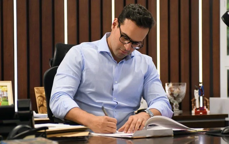 Maringá 98 FM —   O governador Lucas Ribeiro (Progressistas) oficializou, em publicação no Diário Oficial do Estado desta quinta-feira (14/05), novas nomeações para cargos no primeiro escalão e em secretarias executivas do Governo da Paraíba. Entre os nomes anunciados está o de Matheus Cartaxo Pires de Sá Freire, filho do deputado estadual Luciano Cartaxo (Republicanos). Ele foi nomeado para o cargo de secretário executivo de Economia Solidária, vinculado à Secretaria de Estado do Desenvolvimento Humano. Também foi nomeado o ex-prefeito de Prata, Júnior Nóbrega, que passa a comandar a Secretaria da Agropecuária e da Pesca. Outra mudança anunciada pelo governador foi a nomeação […]