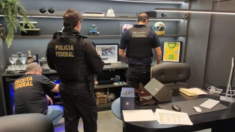 Maringá 98 FM — A Polícia Federal deflagrou nesta quinta-feira (17) a segunda fase da Operação Arena, investigação sobre suspeitas de evasão de divisas, lavagem de dinheiro e outros crimes contra a ordem tributária e financeira. Foram cumpridos cinco mandados de busca e apreensão e um mandado de prisão preventiva em João Pessoa e Campina Grande, além de medidas de sequestro de bens. De acordo com a PF, o alvo foi preso em Jacumã, mas o mandado de prisão era em Campina Grande. A nova etapa dá continuidade à investigação que teve a Pixbet entre os alvos na primeira fase. Na ocasião, a PF apurava [&hellip;]